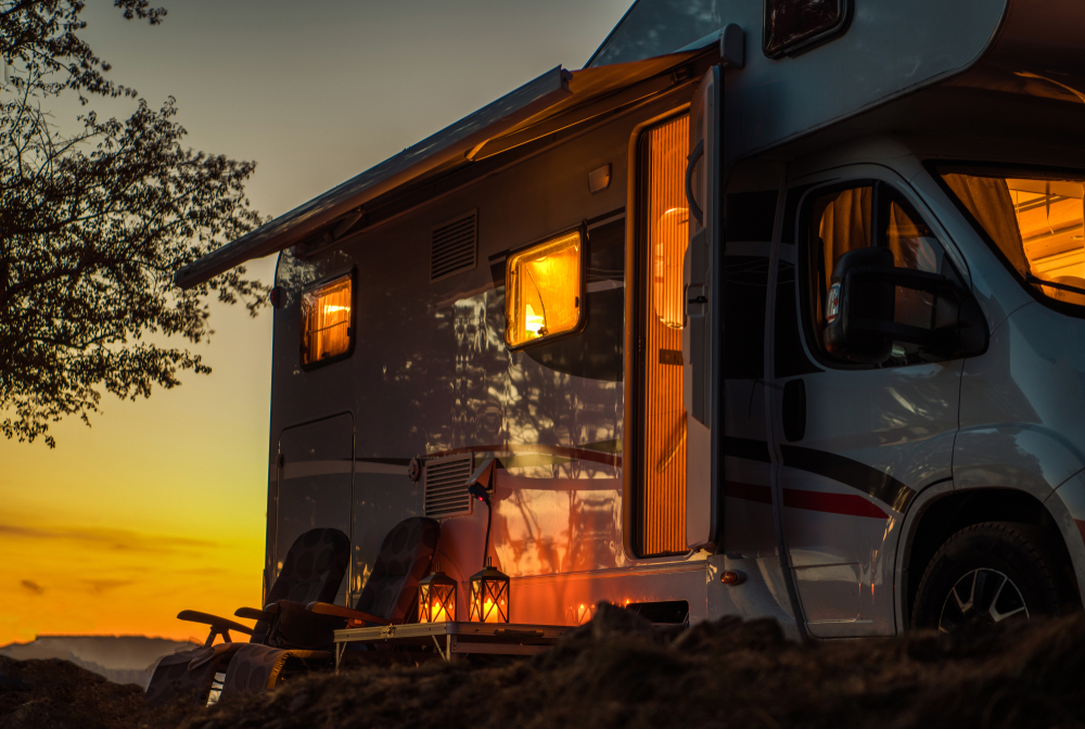 RV camper with lights on at dusk